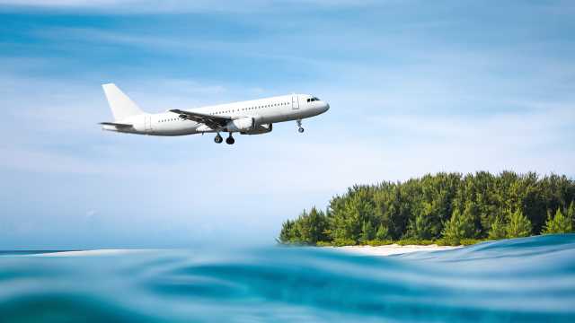 Airplane flying over waves