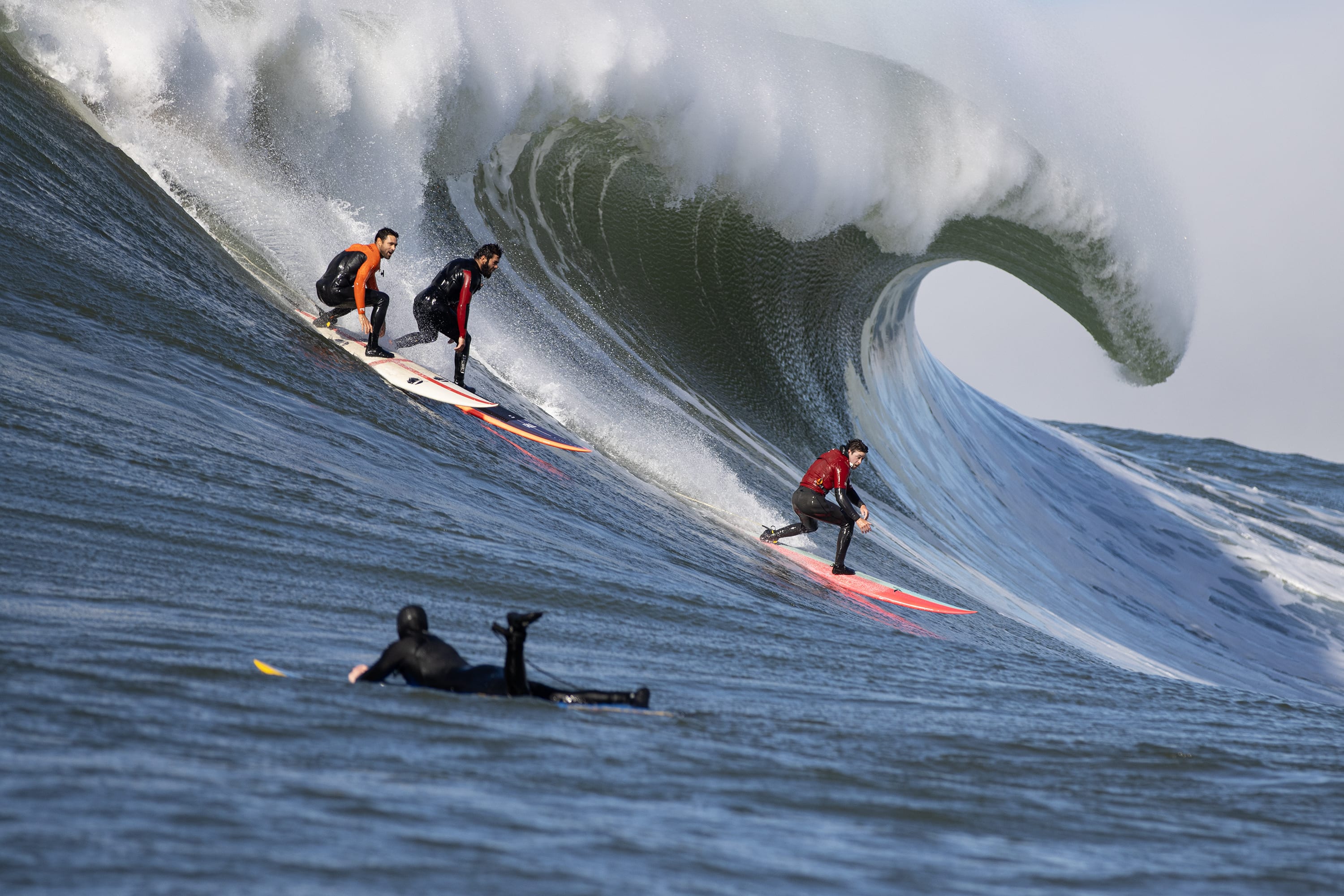 Francisco Porcella, Luca Padua and Hamilton Jacobs ride a wave at Mavericks.